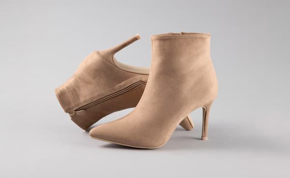 Bottines beiges à talons aiguilles pour femme, une debout et une couchée, fermeture éclair latérale