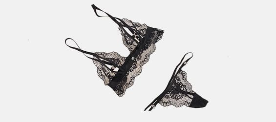 Spitzen-BH und Slip in Schwarz, auf weißem Hintergrund platziert.