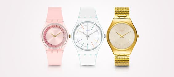 Trois montres élégantes – une rose avec des cristaux, une blanche avec des détails colorés, et une dorée avec bracelet métallique