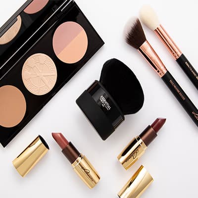 Make-up-Set mit Contouring-Palette, großem Puderpinsel, zwei schmalen Pinseln und drei geöffneten Lippenstiften