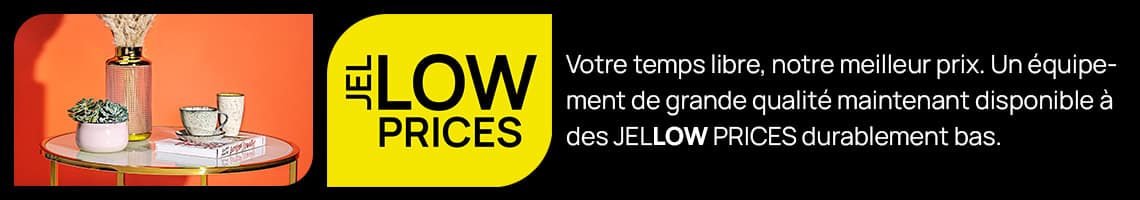 Ihre Freizeit, unser Bestpreis – JELLOW PRICES neben rundem Tisch mit Deko vor orangefarbener Wand