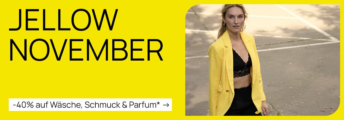 Jellow November - 40 % auf Wäsche, Schmuck & Parfum – Frau in gelbem Blazer und schwarzem Spitzenoberteil geht draußen