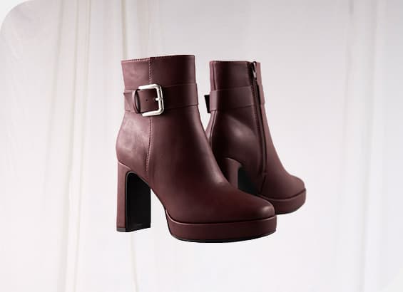 Dunkelrote Stiefeletten mit silberner Schnalle und blockigem Absatz, vor weißem Hintergrund