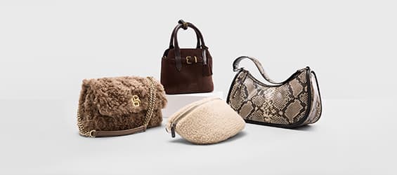 Vier Handtaschen in verschiedenen Stilen, umgeben von rosa Blütenblättern.