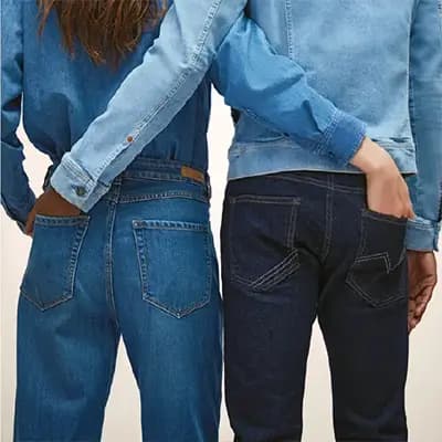 Zwei Personen in Jeans von hinten, eine Hand in der eigenen, die andere in der Gesäßtasche der anderen Person
