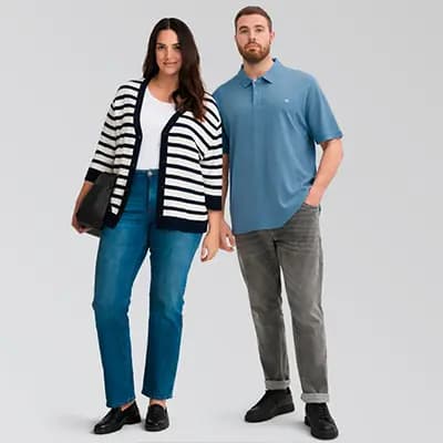 Frau in gestreifter Strickjacke und Jeans steht neben Mann in blauem Poloshirt und grauer Hose vor hellem Hintergrund