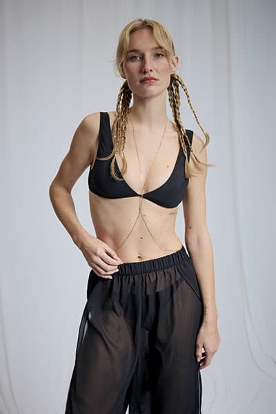 Personne debout en haut de bikini jaune à franges, short en jean bleu et chemise blanche nouée à la taille