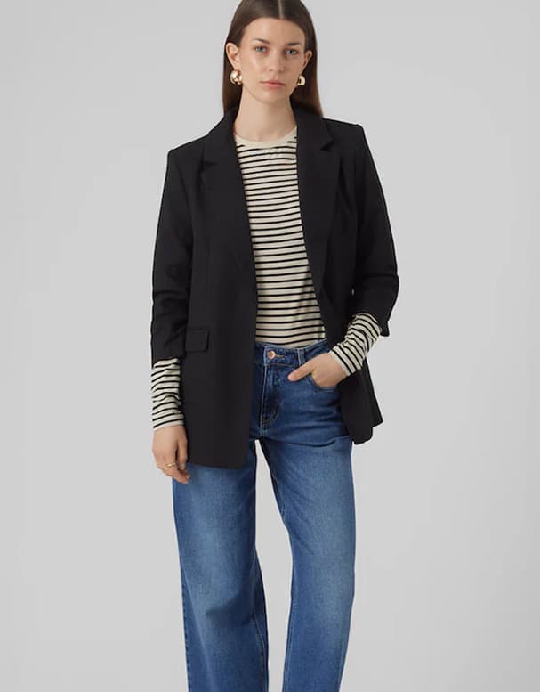 Frau trägt gestreiftes Langarmshirt, schwarzen Blazer und blaue Jeans.