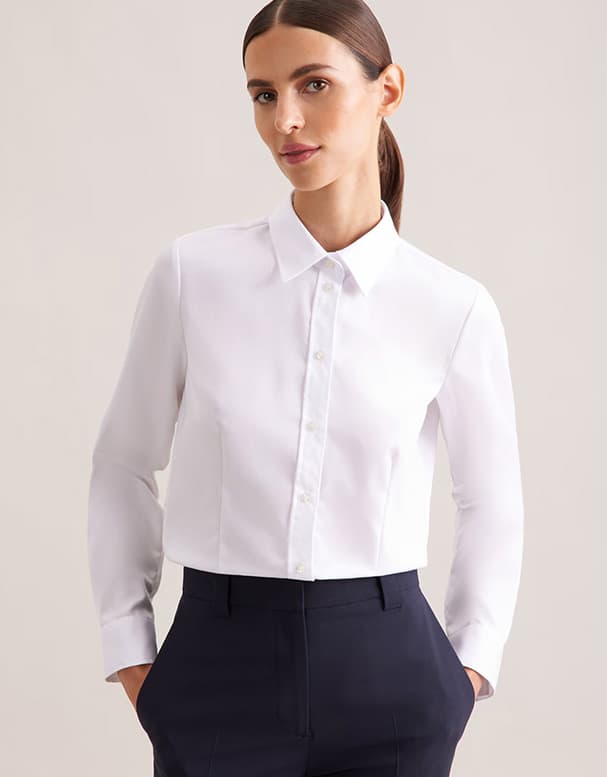 Personne debout de dos portant t-shirt noir, pantalon de survêtement noir à bandes blanches et escarpins à talons