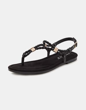 Sandale plate noire pour femme avec bride tressée et détails métalliques dorés, vue de profil sur fond clair